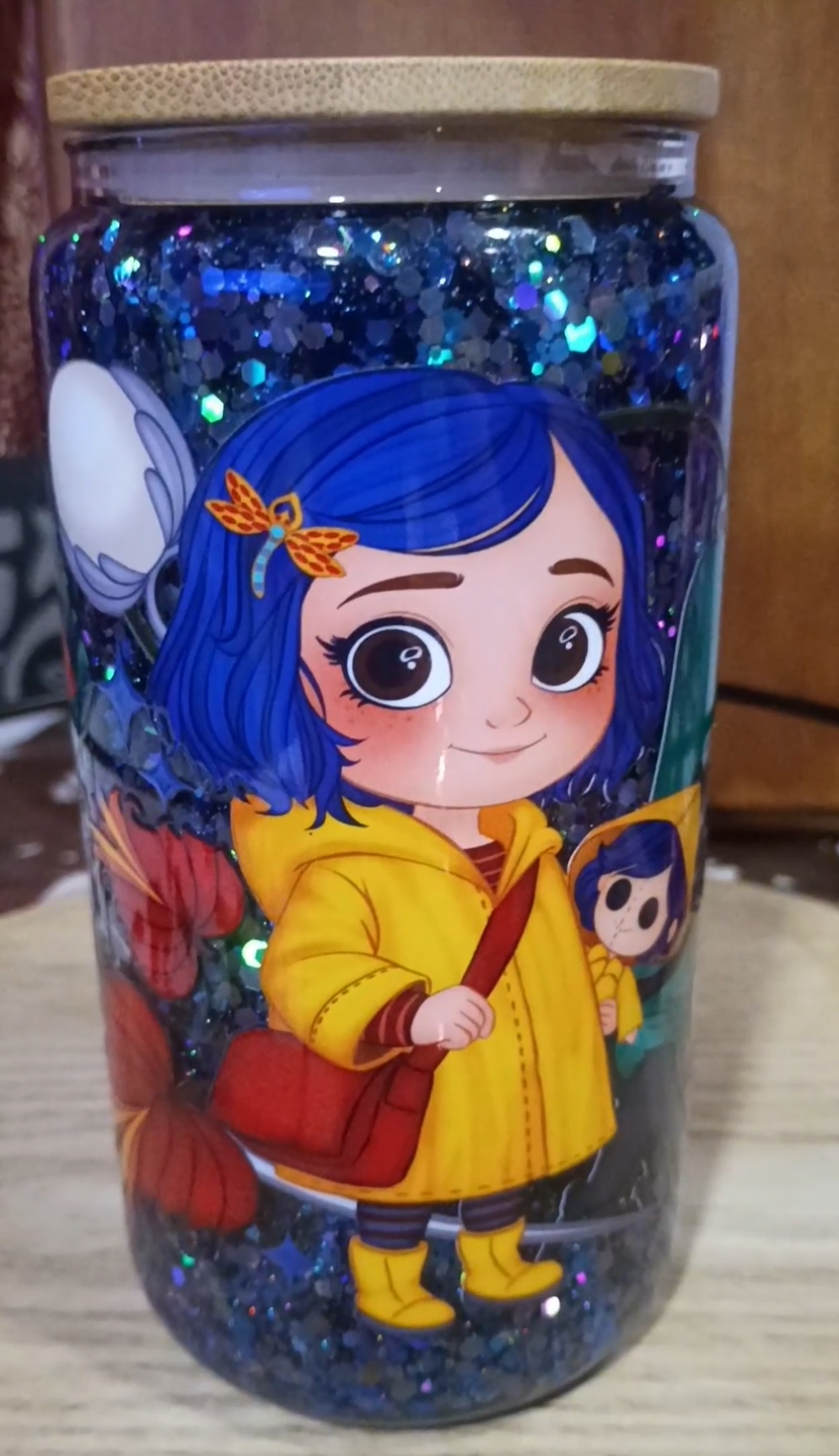 Custom Coraline Glitter Snow Globe Tumbler with deep blue holographic glitter, Coraline character art, and bamboo lid